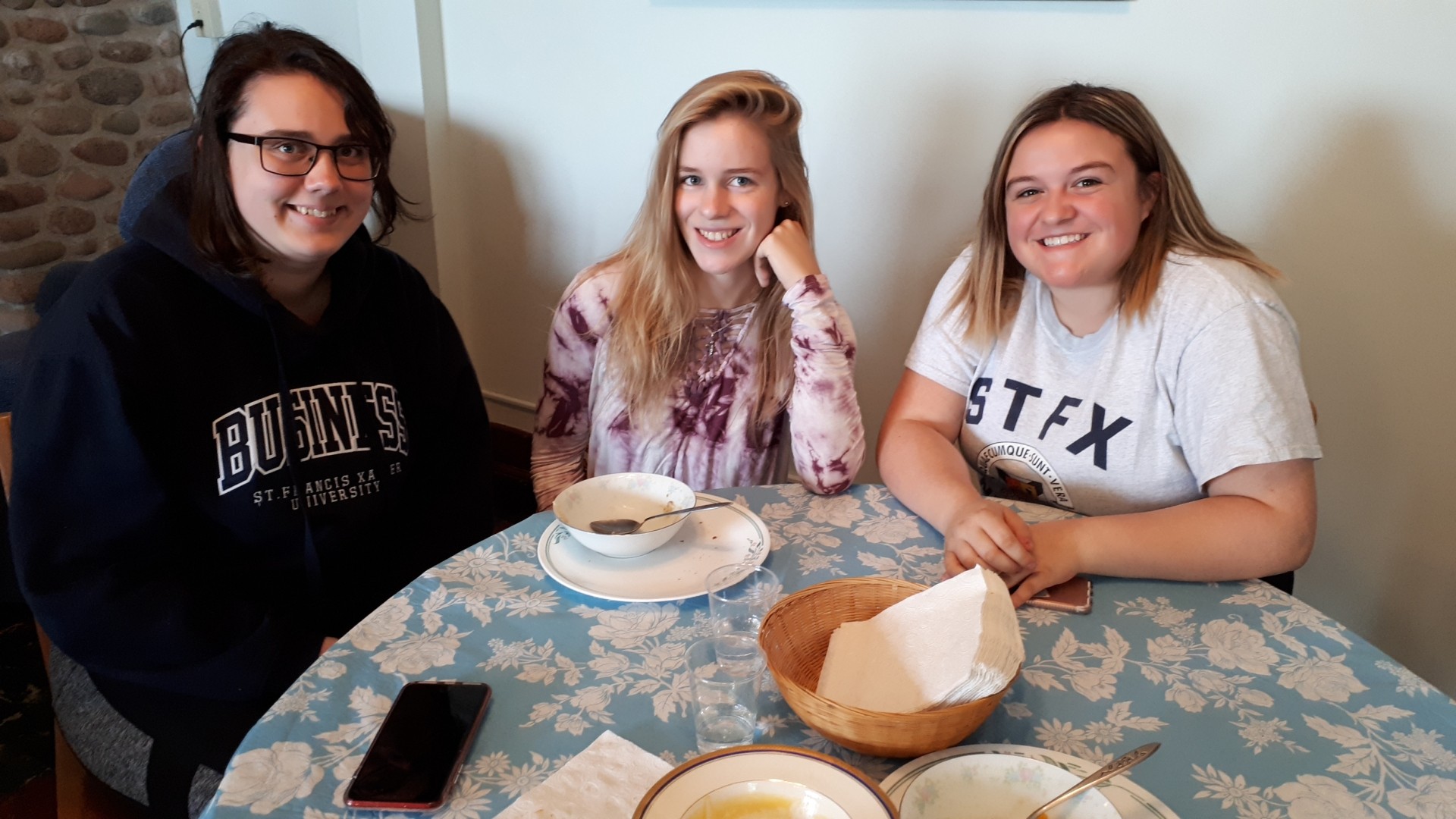 Three people sitting at a table and smiling