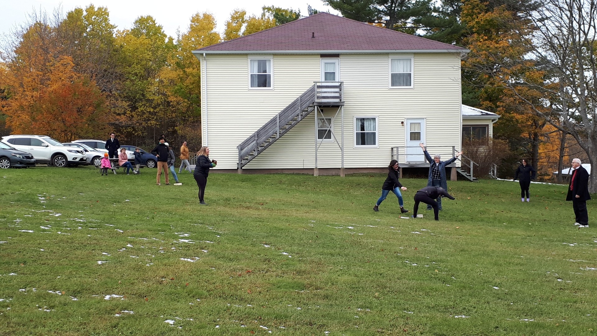 People in a large yard in front of a house