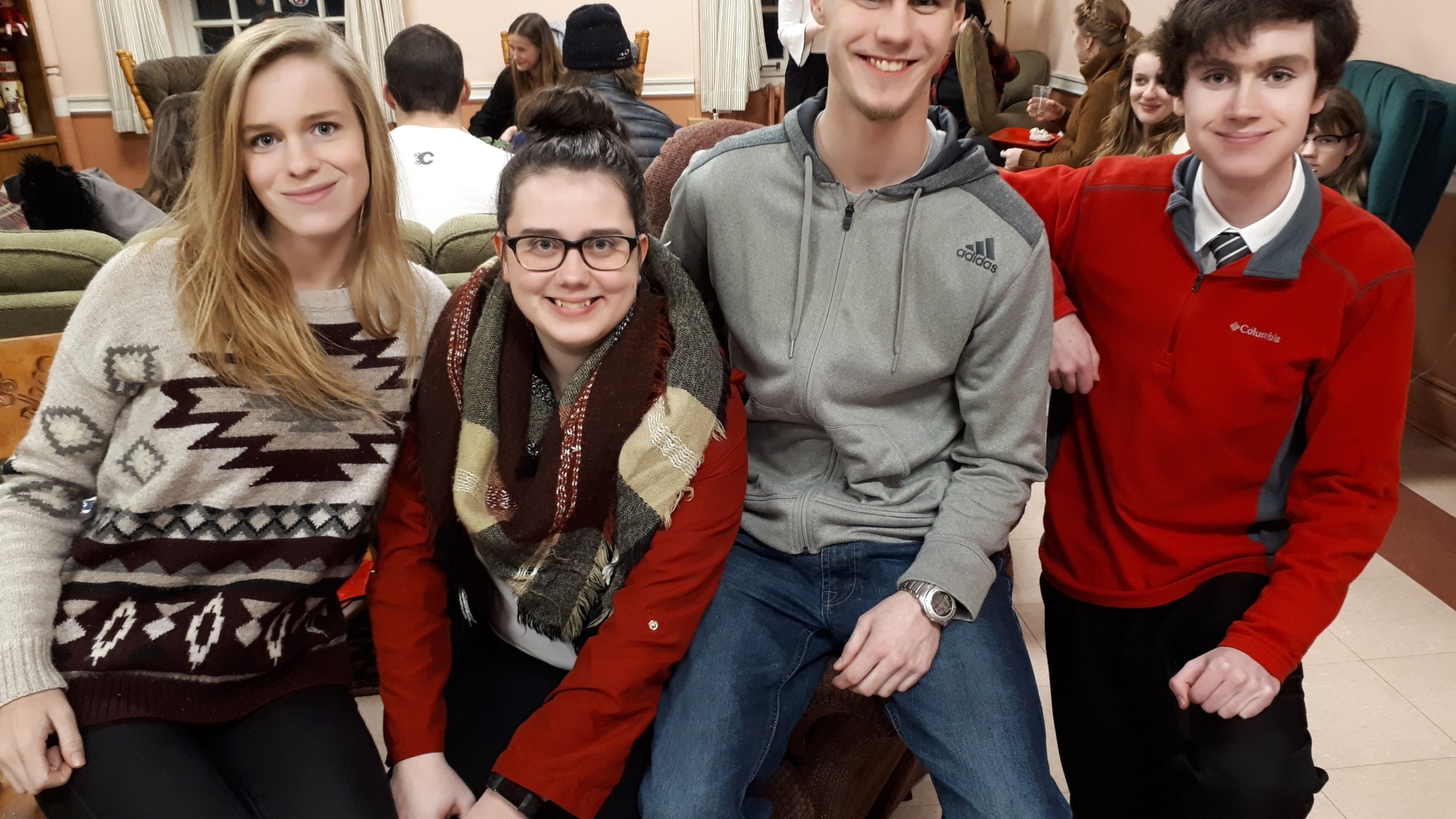 Four people sitting and smiling