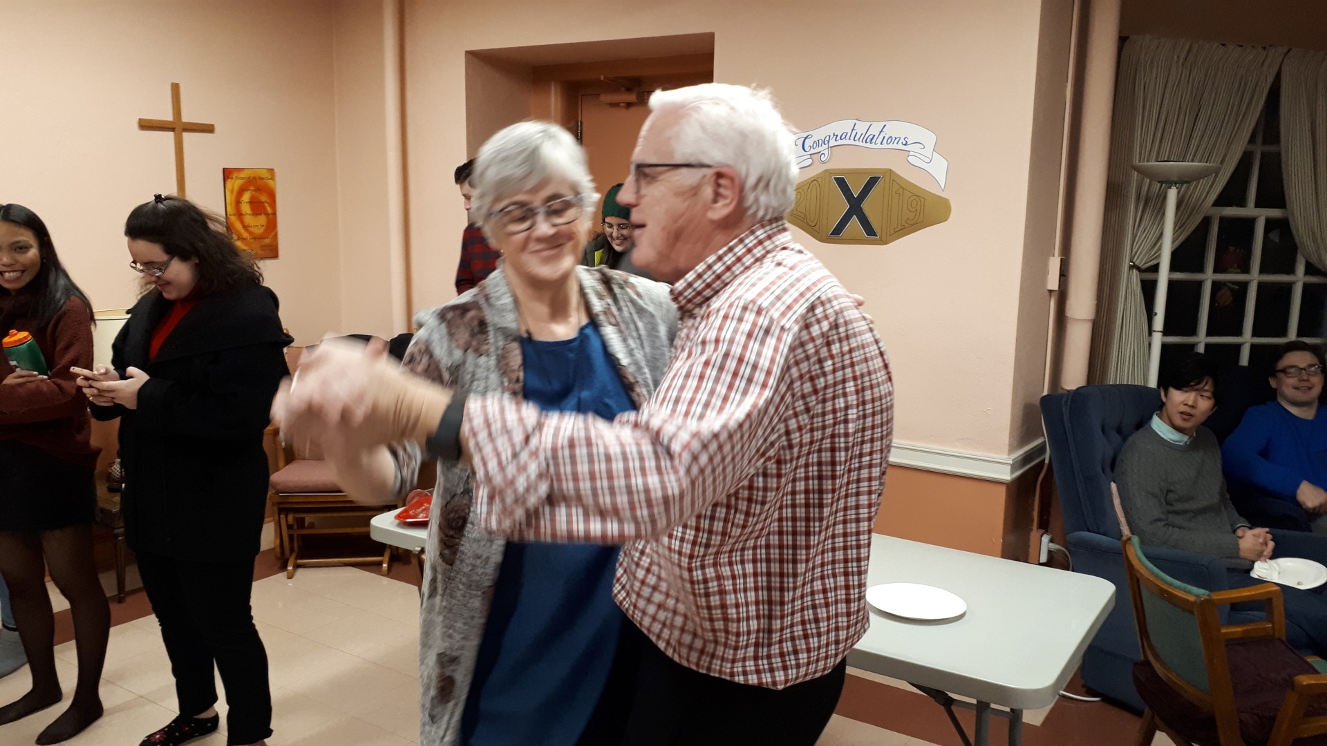 Two people dancing with others gathered around