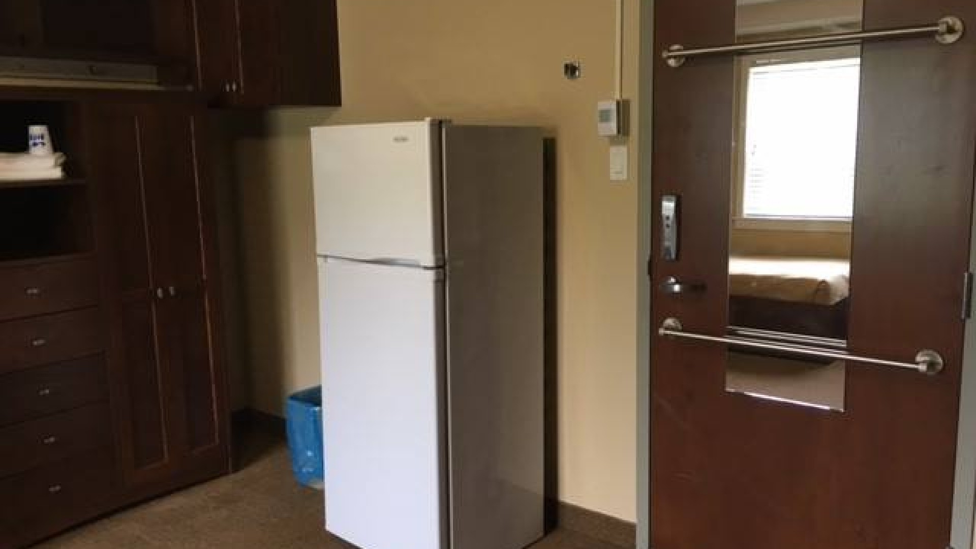 Inside a double room with a large fridge near the door