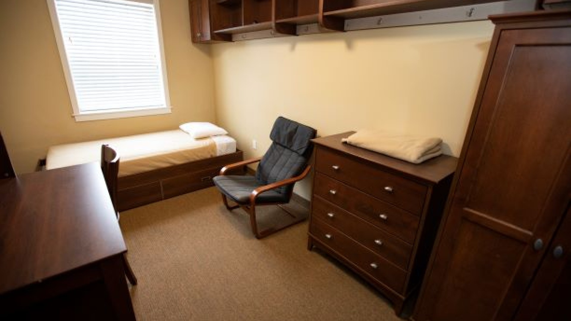 Single furnished room with computer table, chair, bed and closet