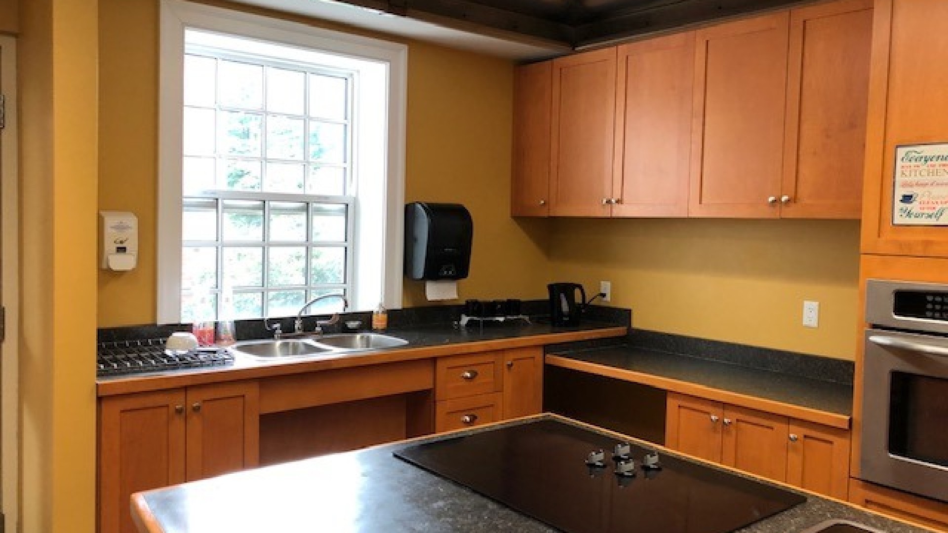 Kitchen space with a sink and a window above