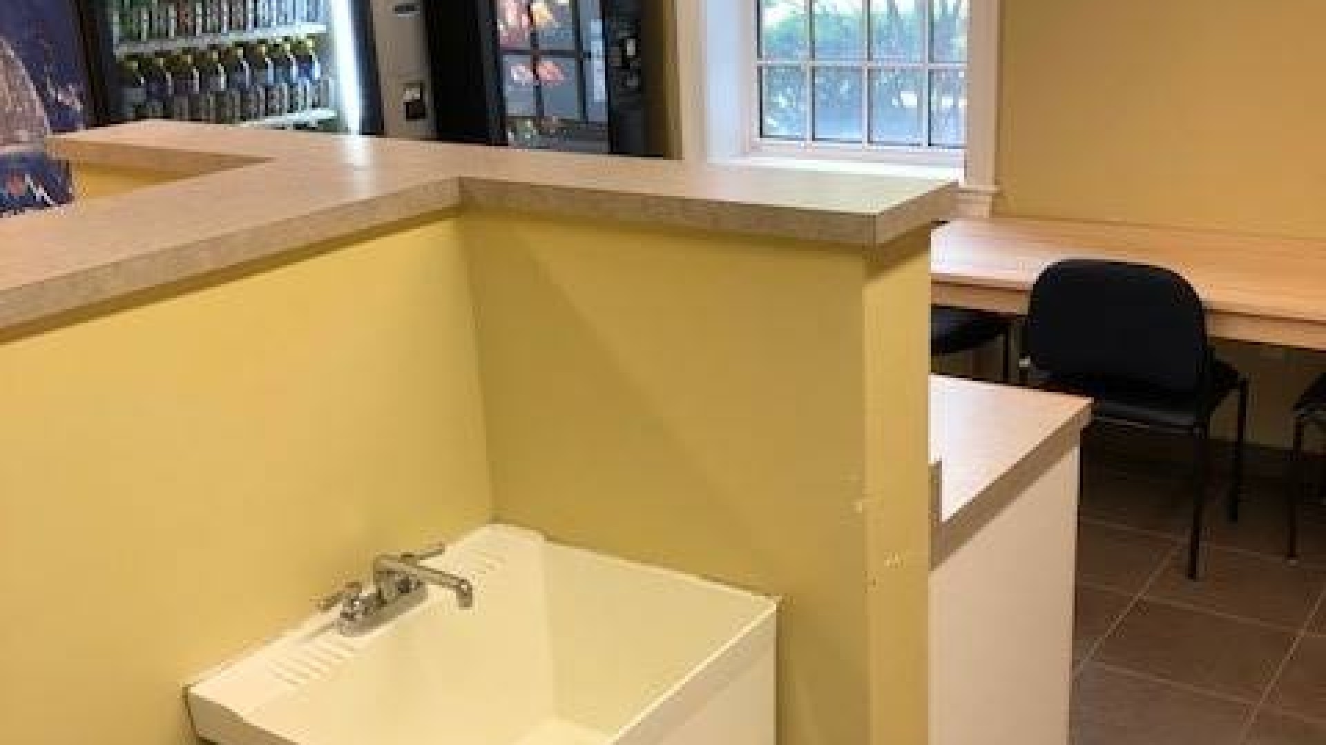 Laundry facilities with a sink and vending machine.
