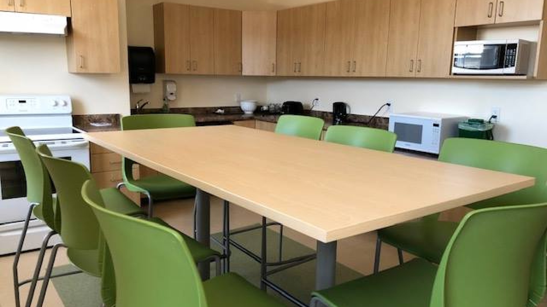 Table and chairs with a kitchen in the background 