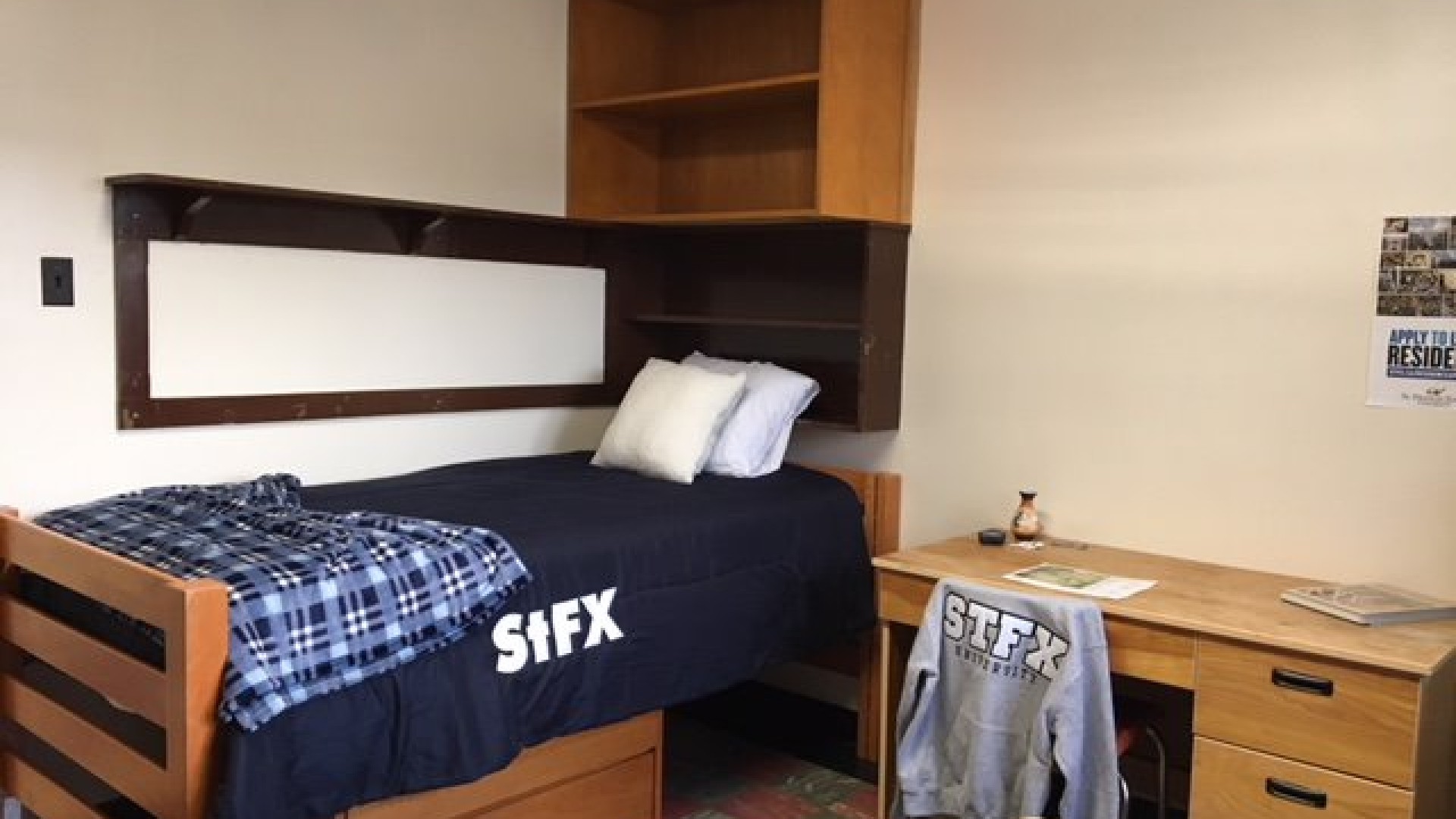 Room with a bed, desk and storage space 