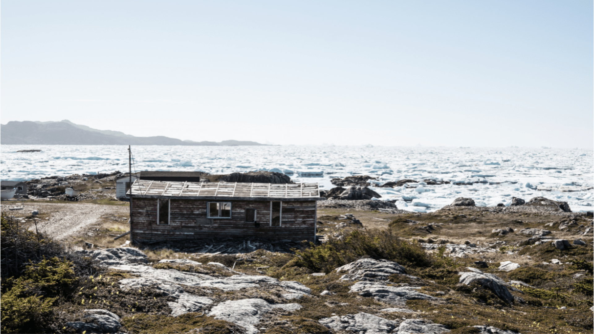 Cabin near the shore of Fogo Island with icy water