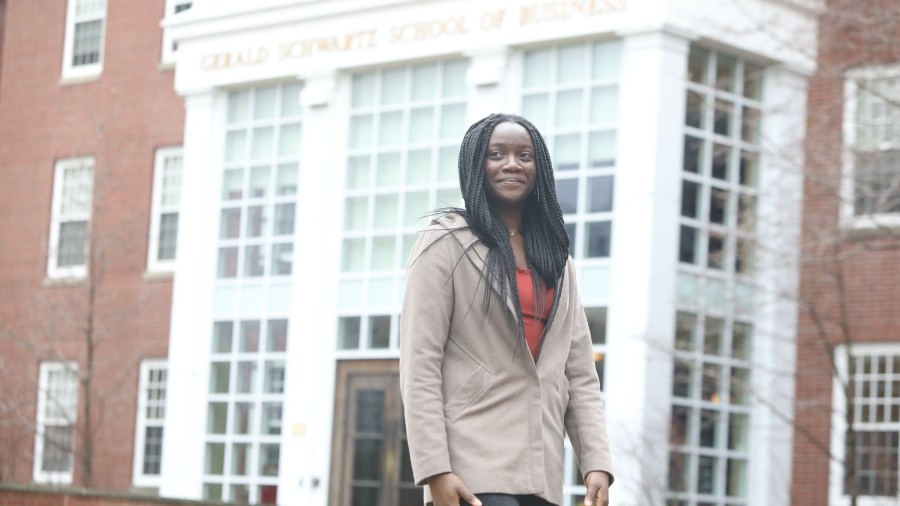Student walking in front of the Gerald Schwartz School of Business.