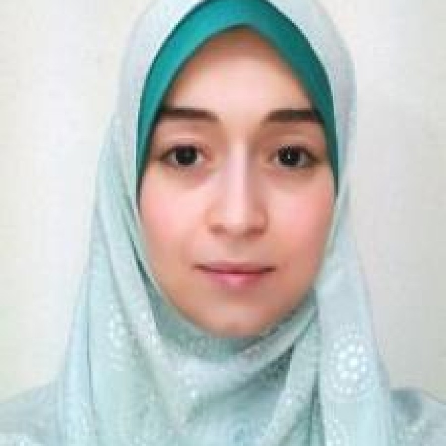 A woman in a headscarf smiles for the camera