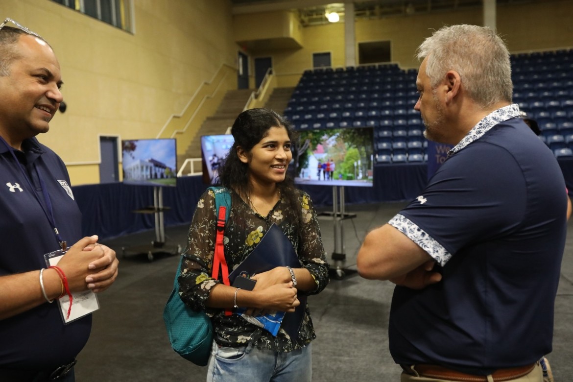 Dr. Andy Hakin speaks with an international student and student recruiter at Welcome Day.