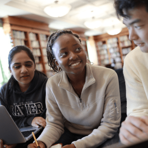 3 Students Sit Together in the Library