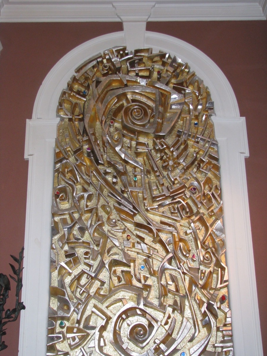 A carved gold-painted panel featuring religious symbolism.