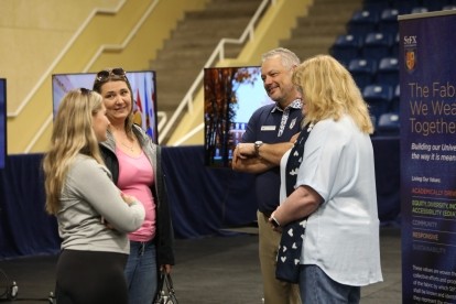 Dr. Andy Hakin and Linda Hakin greet a student and parent at Welcome Day 2023.