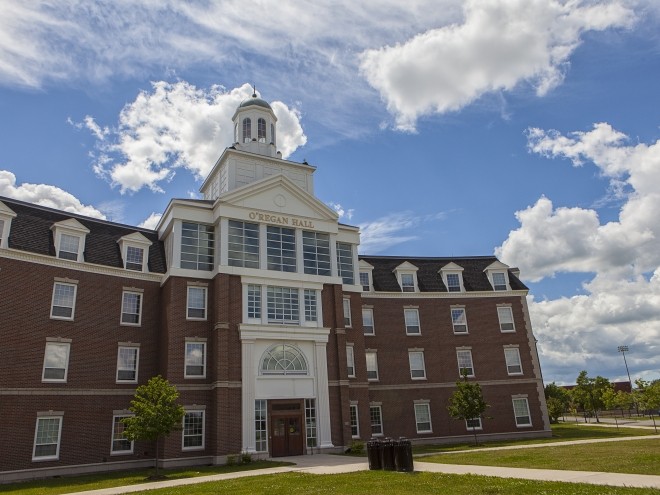 O'Regan Hall exterior main entrance on a summer day with a few clouds in the sky.
