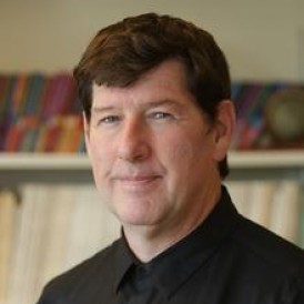 A person in front of a bookcase